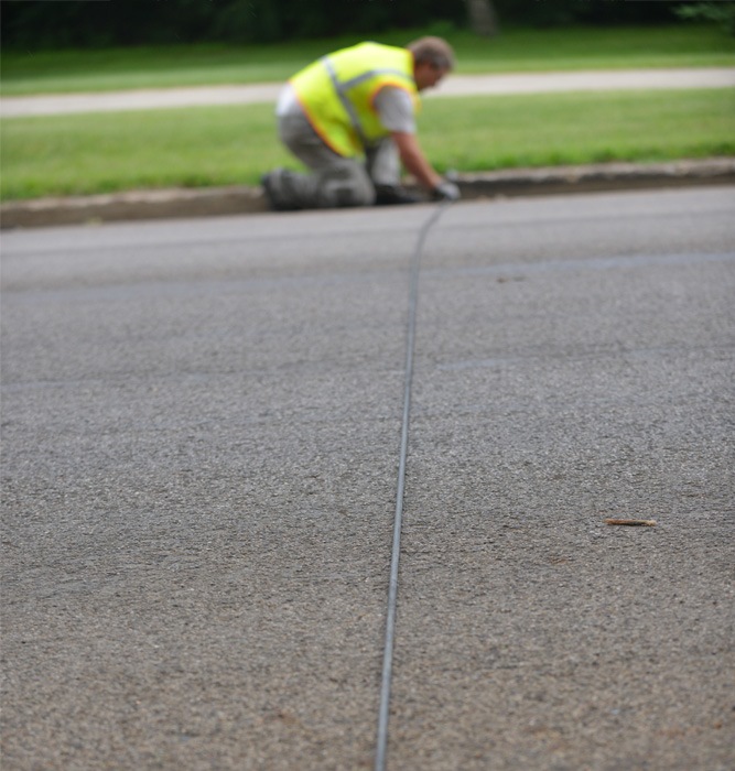 Man laying down a sensor to collect traffic data