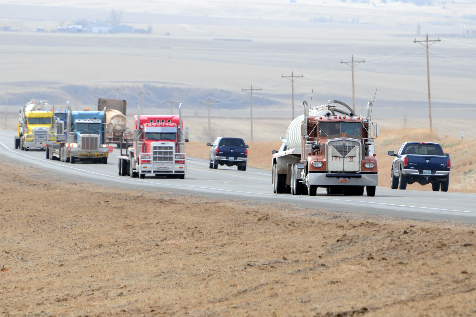 Semi trucks and passenger vehicles traveling on North Dakota state highway.