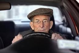 Older man behind the wheel of a car.