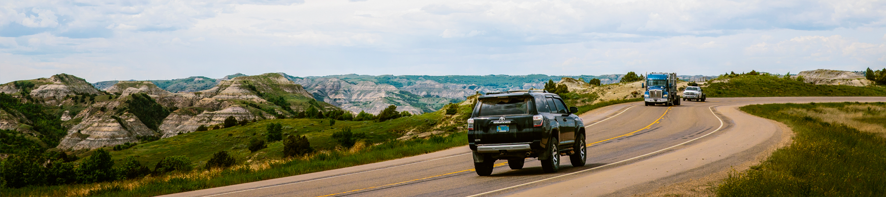 Cars driving through Theodore Roosevelt National Park.