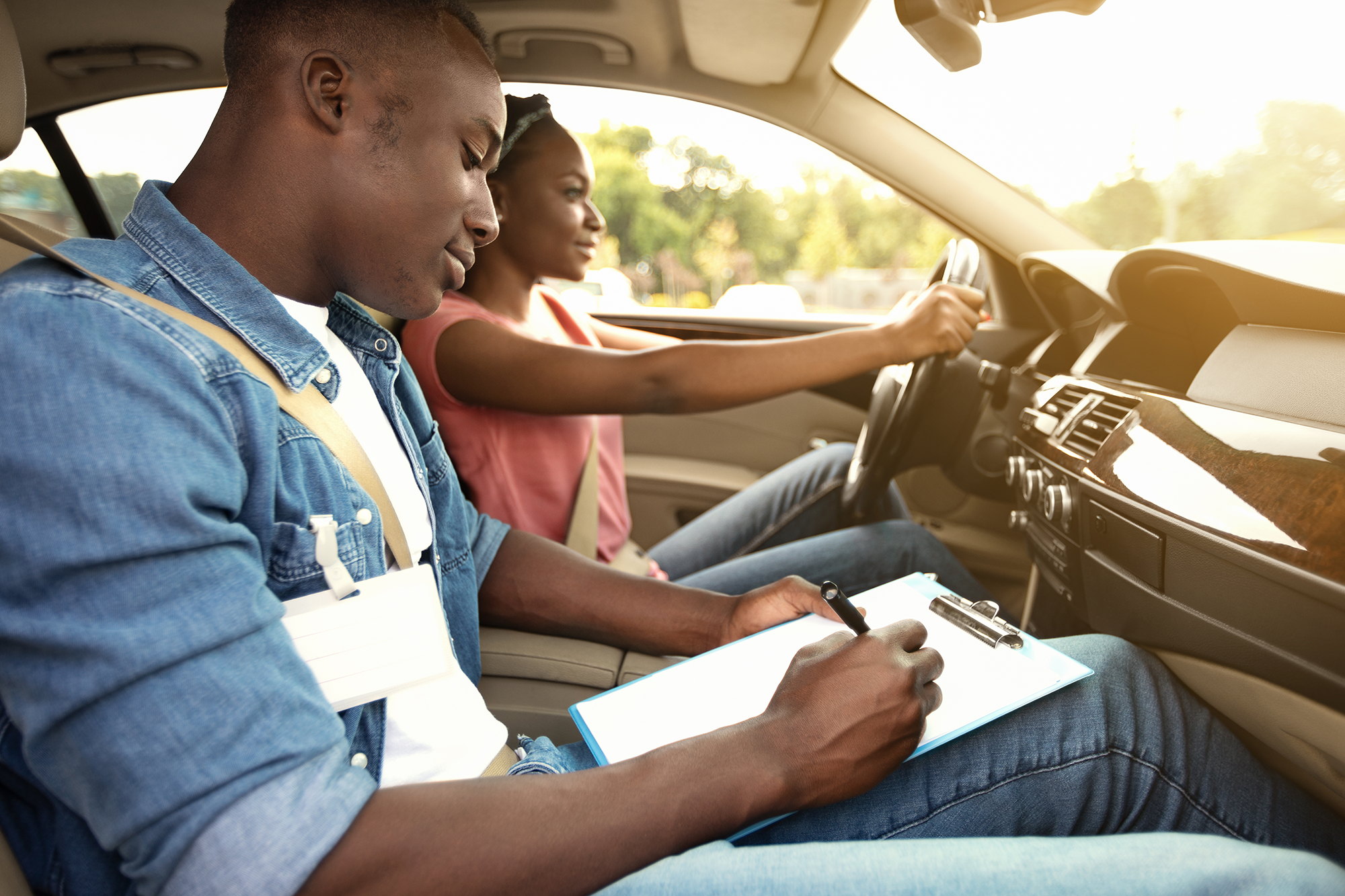 Driving school instructor gives young woman driving lessons.