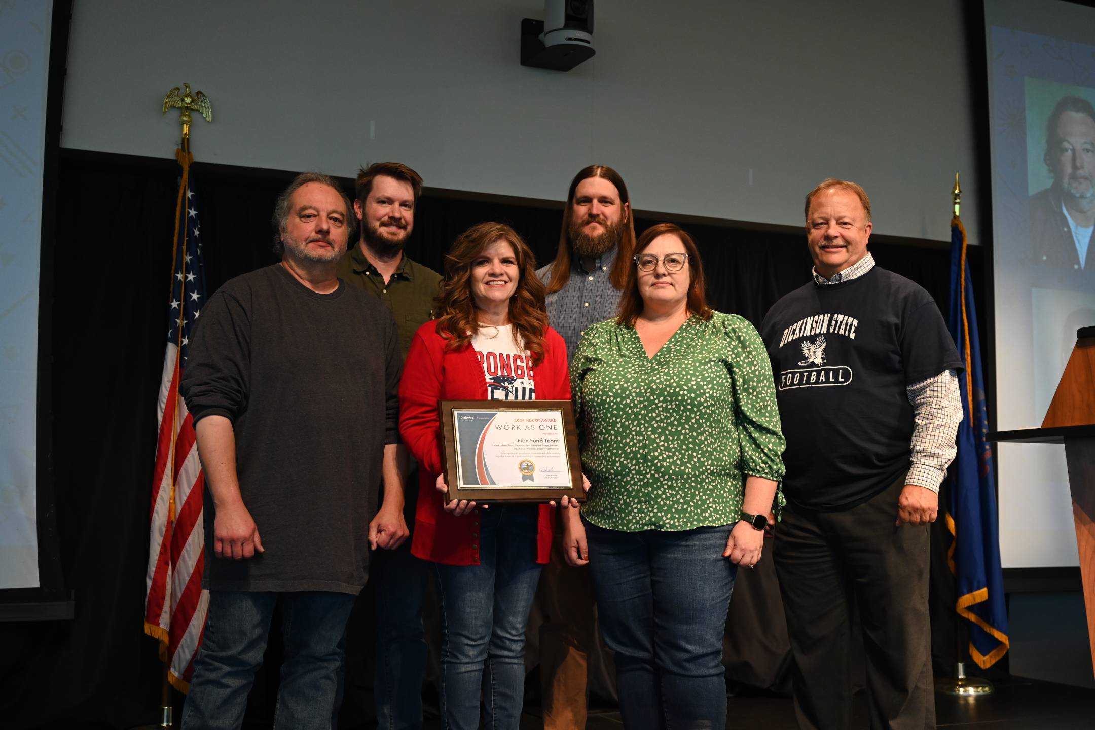 a group of six people, one holding an award