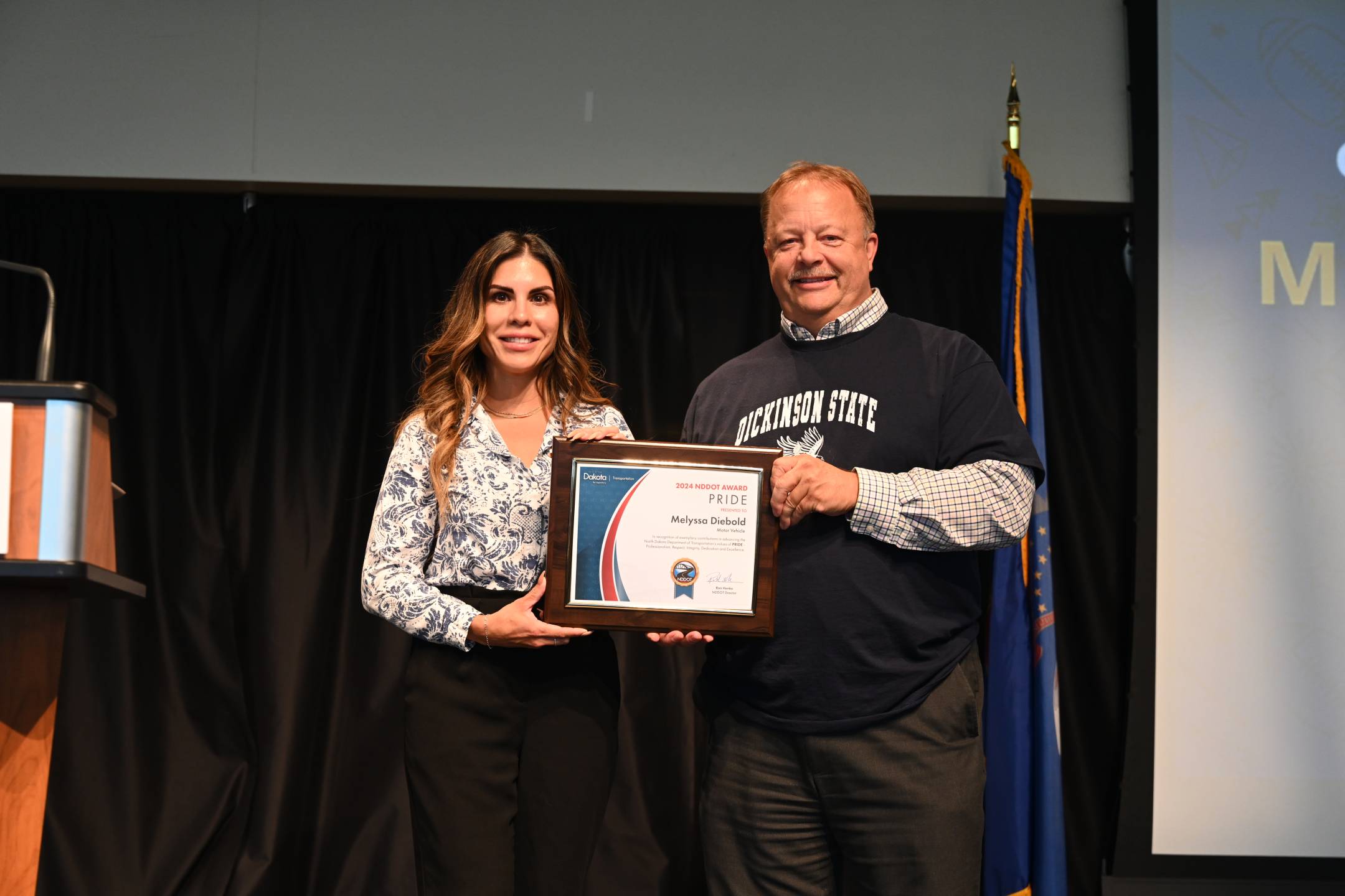 a man and a woman hold an award