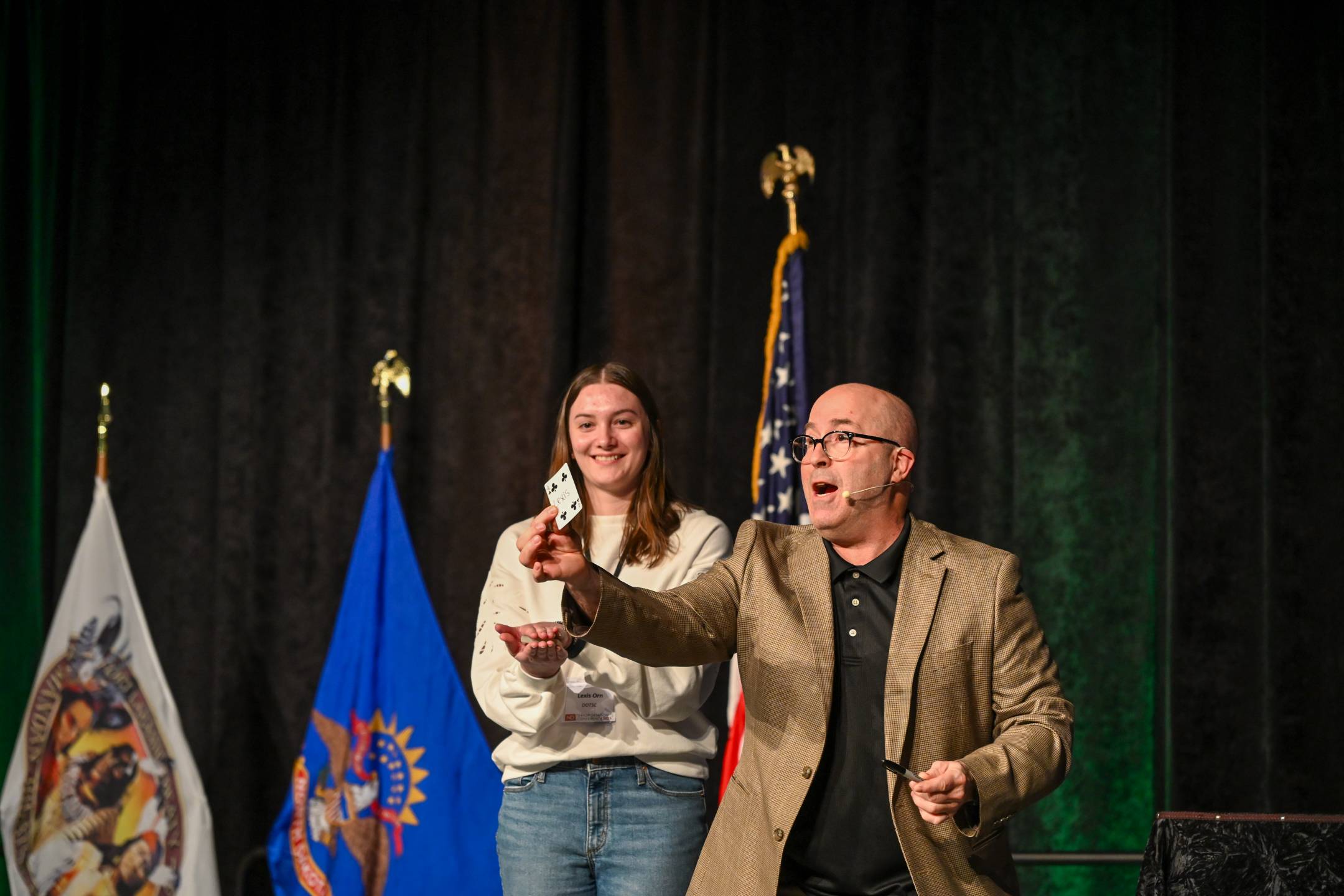 Keynote speaker Stuart MacDonald performs the worlds longest card trick for NDDOT employee Lexis Orn at the 2025 North Dakota Transportation Conference.