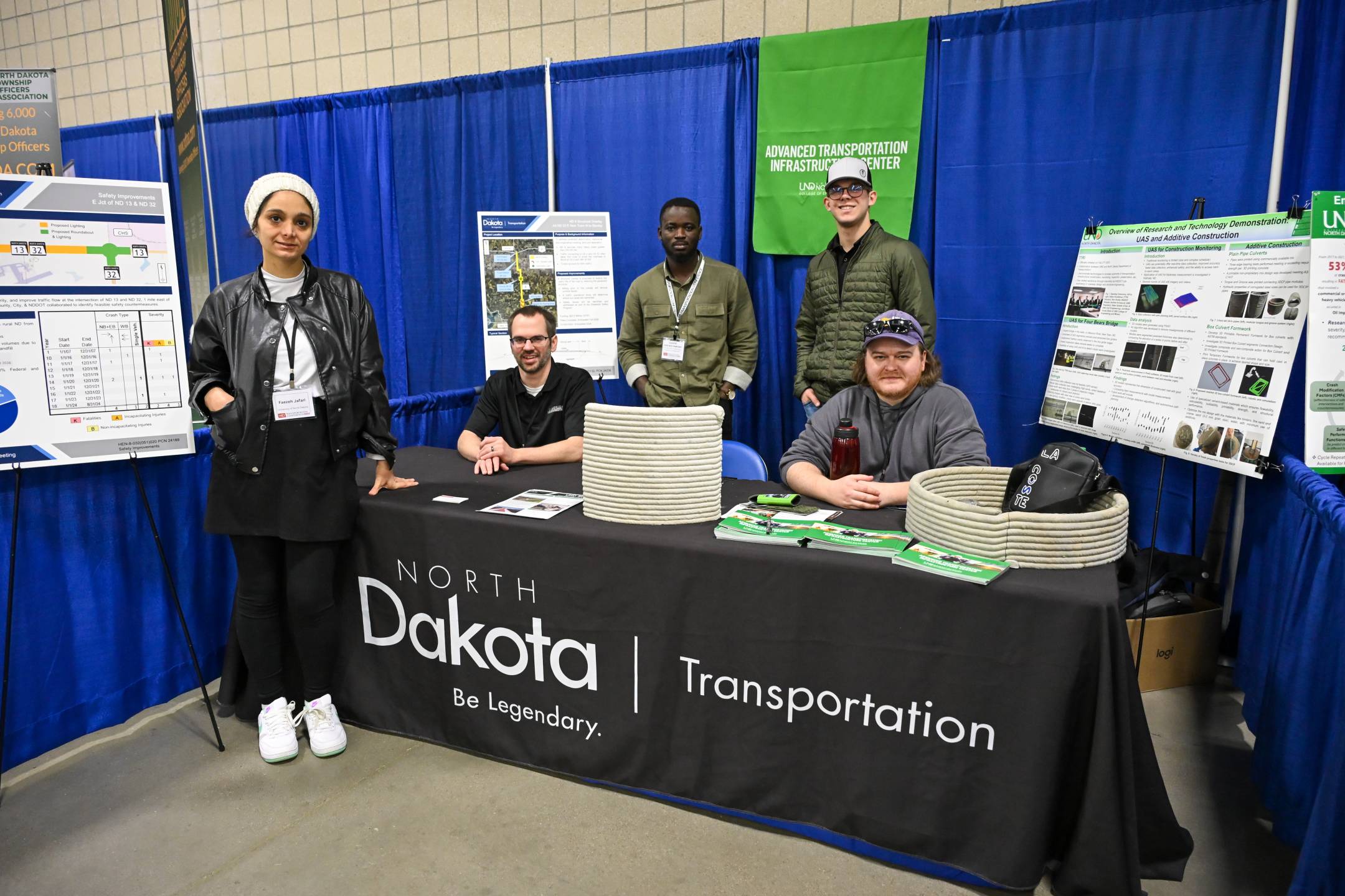 Faezeh jafari, Eugene Assuah-Damoah and others behind theAdvanced Transportation Infrastructure Center booth at the 2025 North Dakota Transportation Conference.