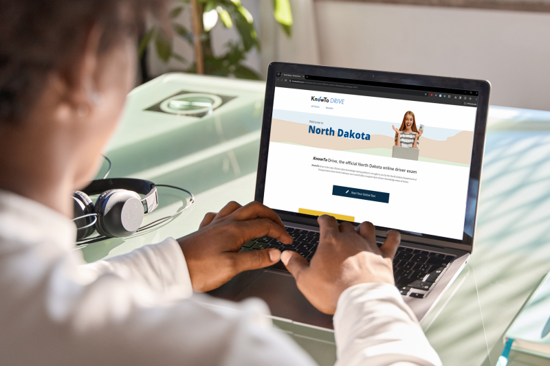 Teen on computer taking the NDDOT online knowledge test.