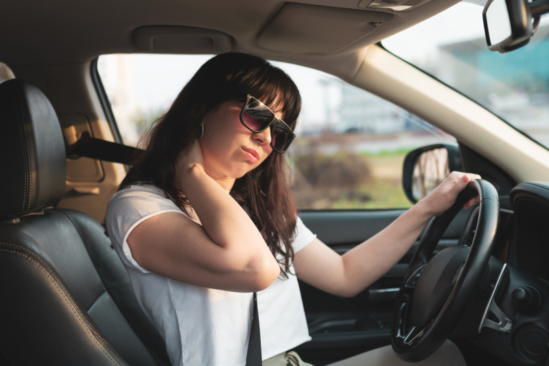 Tired driver rubbing her neck.